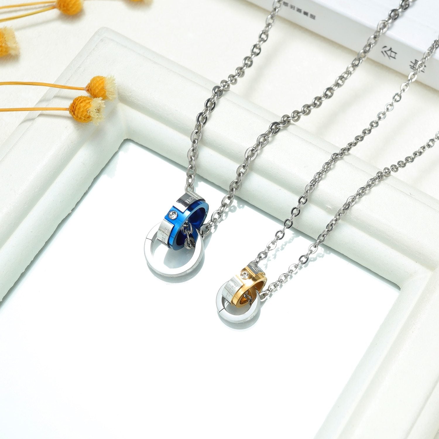 Layered pendant necklaces on a pale background